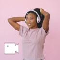 una chica con una camiseta rosa y auriculares