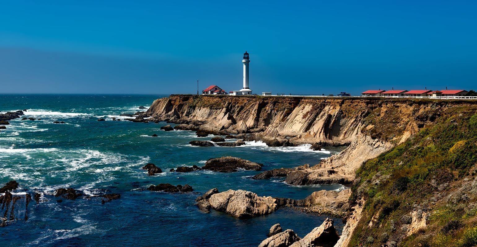 Fotorの無料オンライン画像鮮明化ツールによって鮮明さと細部が強化された海辺の灯台の風景画像